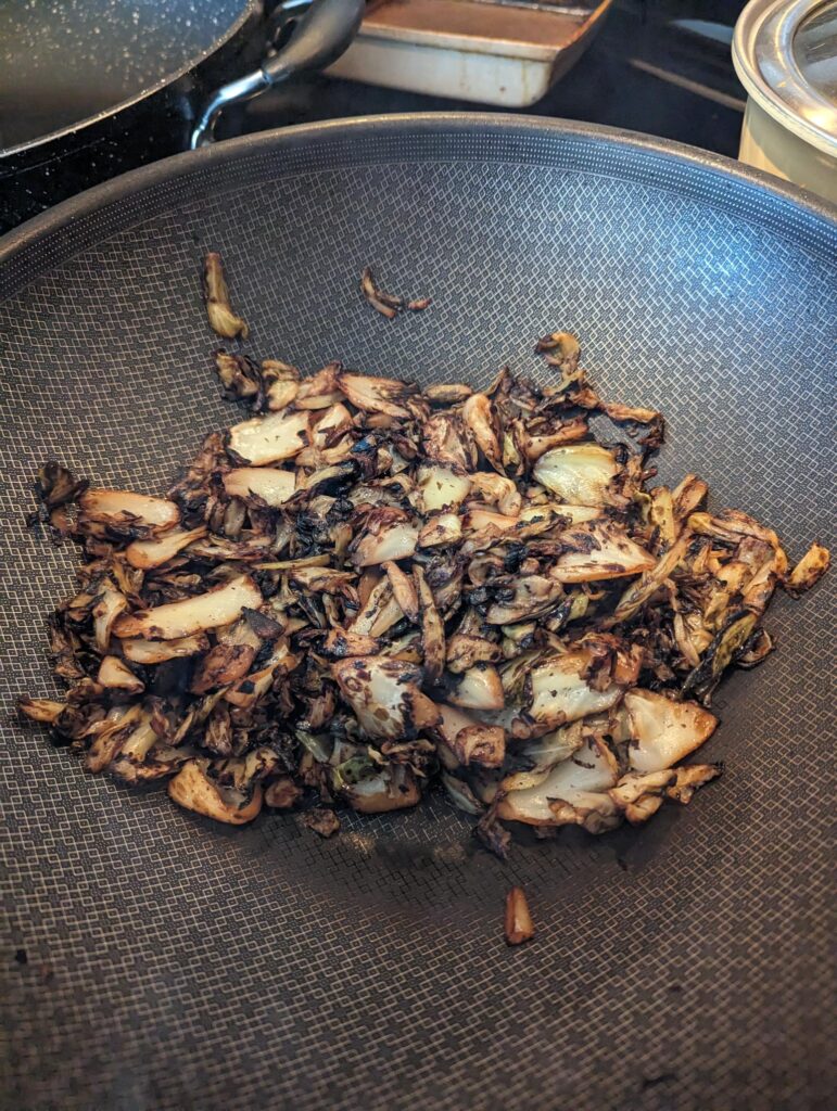 Charred cabbage in a wok.